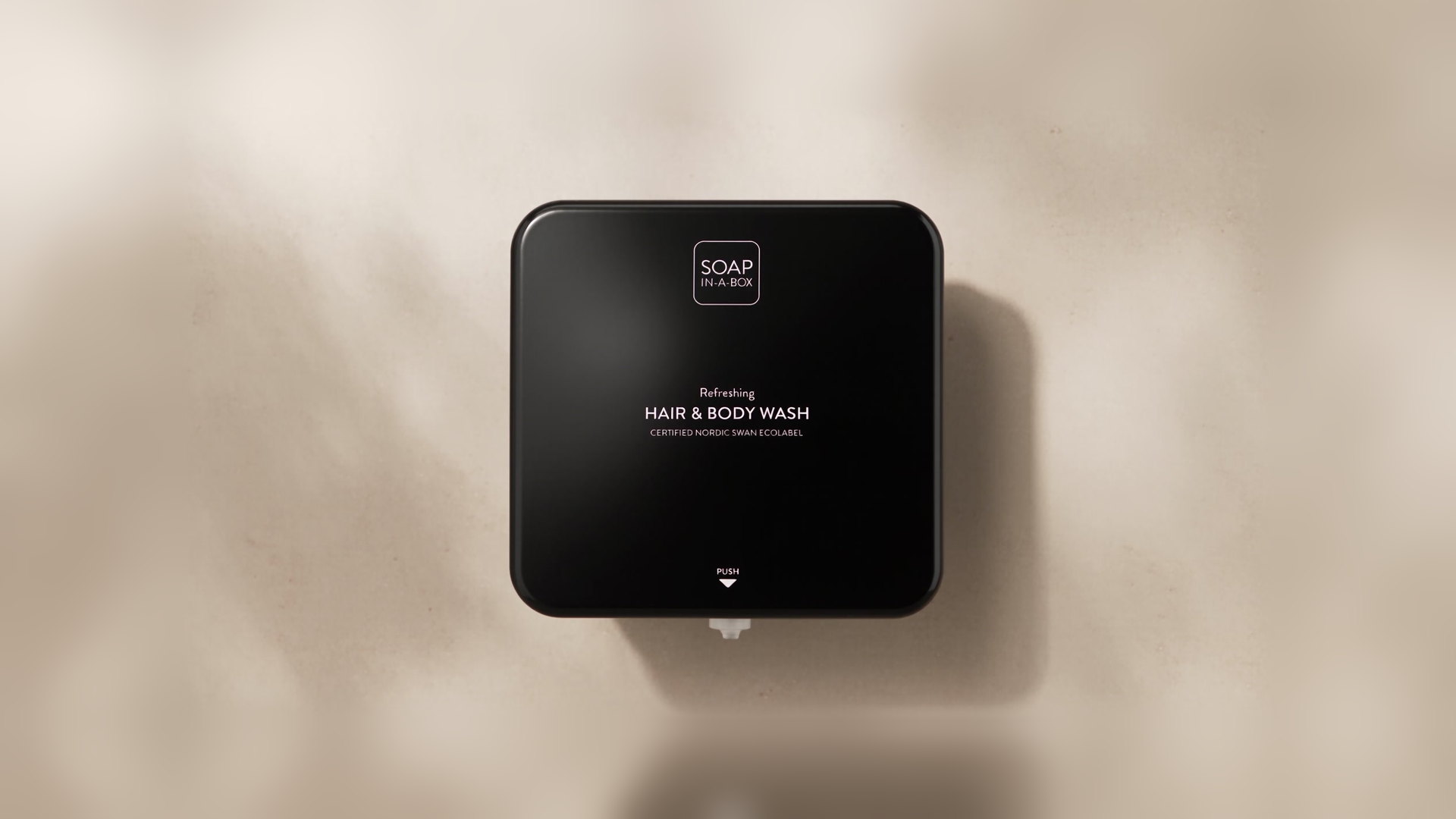 Svart Soap In A Box-dispenser, Hair & Body Wash, på cremefärgad vägg